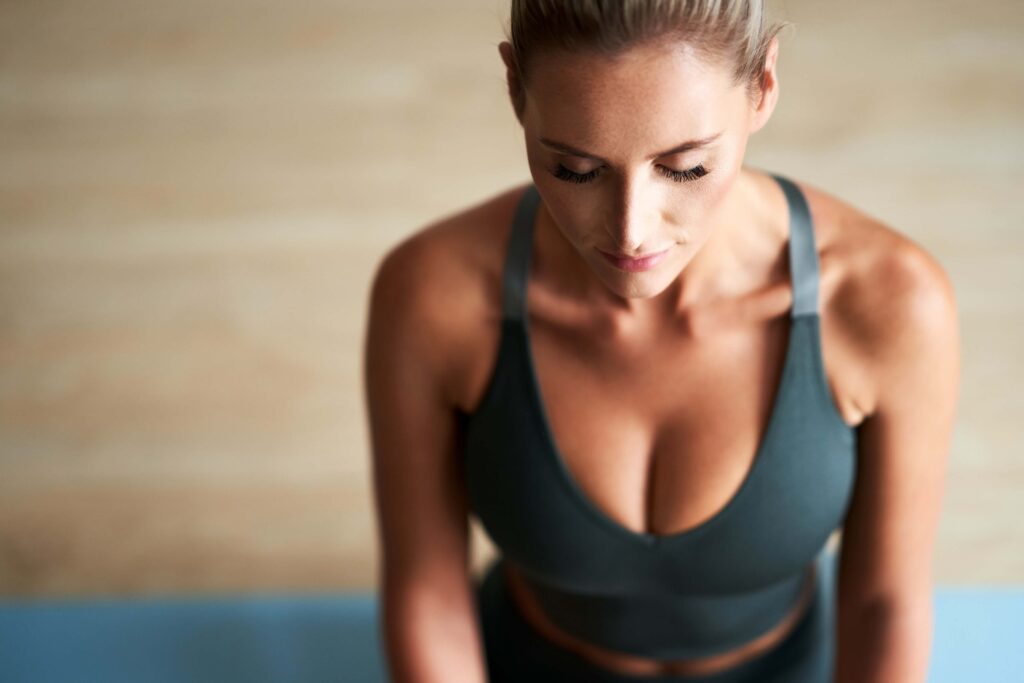 athletic woman on a yoga mat meditating