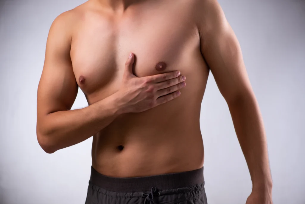 A man touching his chest to show results of breast reduction surgery.