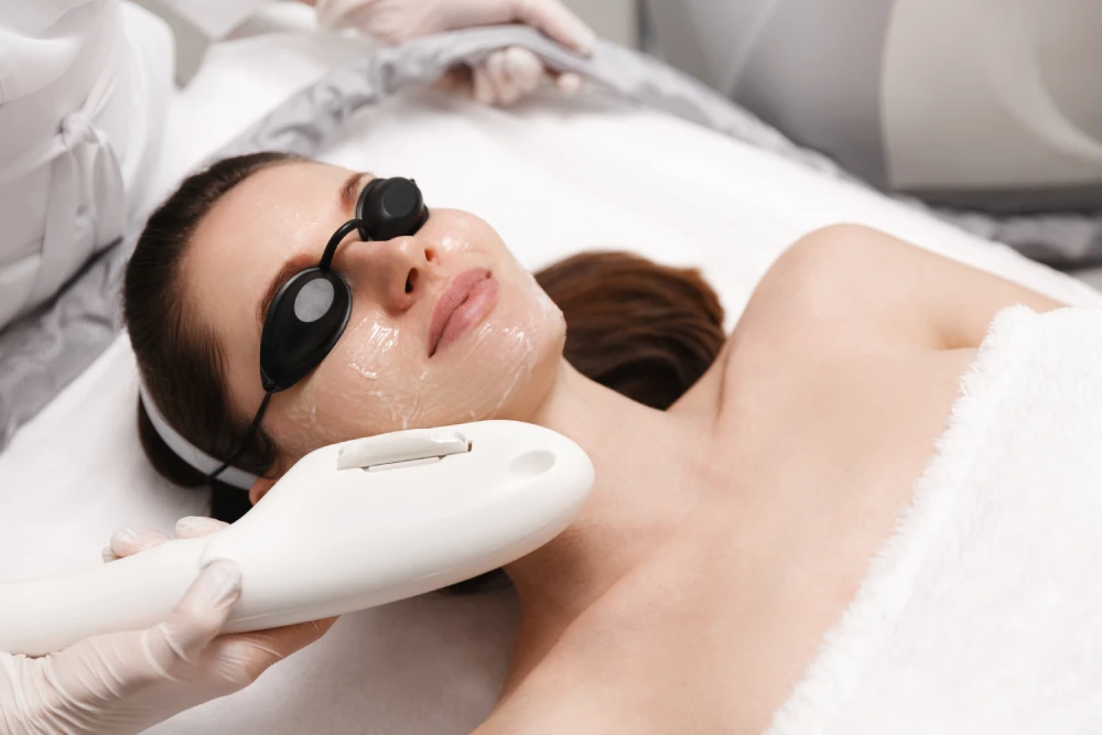 Woman undergoing a BBL session wearing protective goggles.
